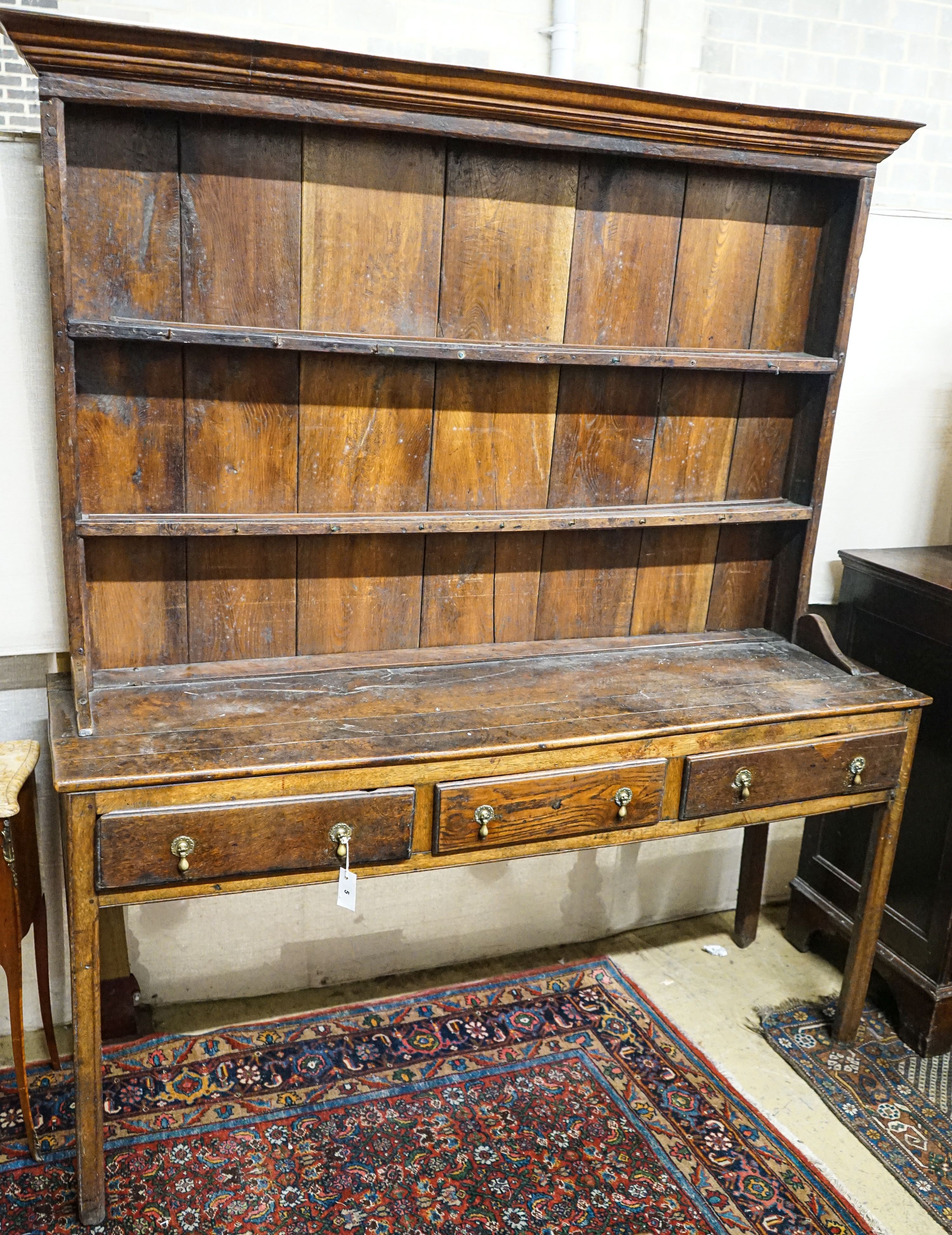 A George III oak dresser, with two shelf rack and three long drawers, on chamfered legs, width 167cm, depth 49cm, height 193cm